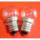 Two 6V 6W E10 base Krypton light bulbs with clear glass on an orange background